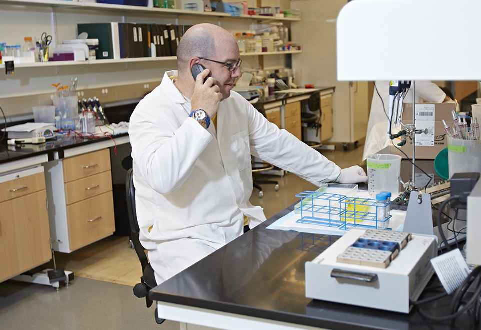 Scientist in lab on phone